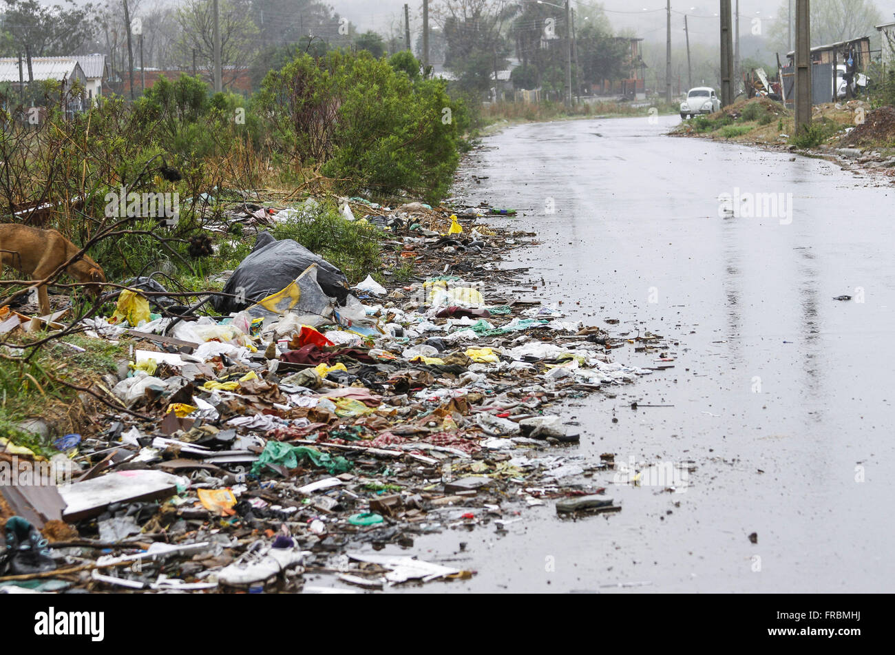 Trash-strewn street in a poor neighborhood on the outskirts of the city Stock Photo