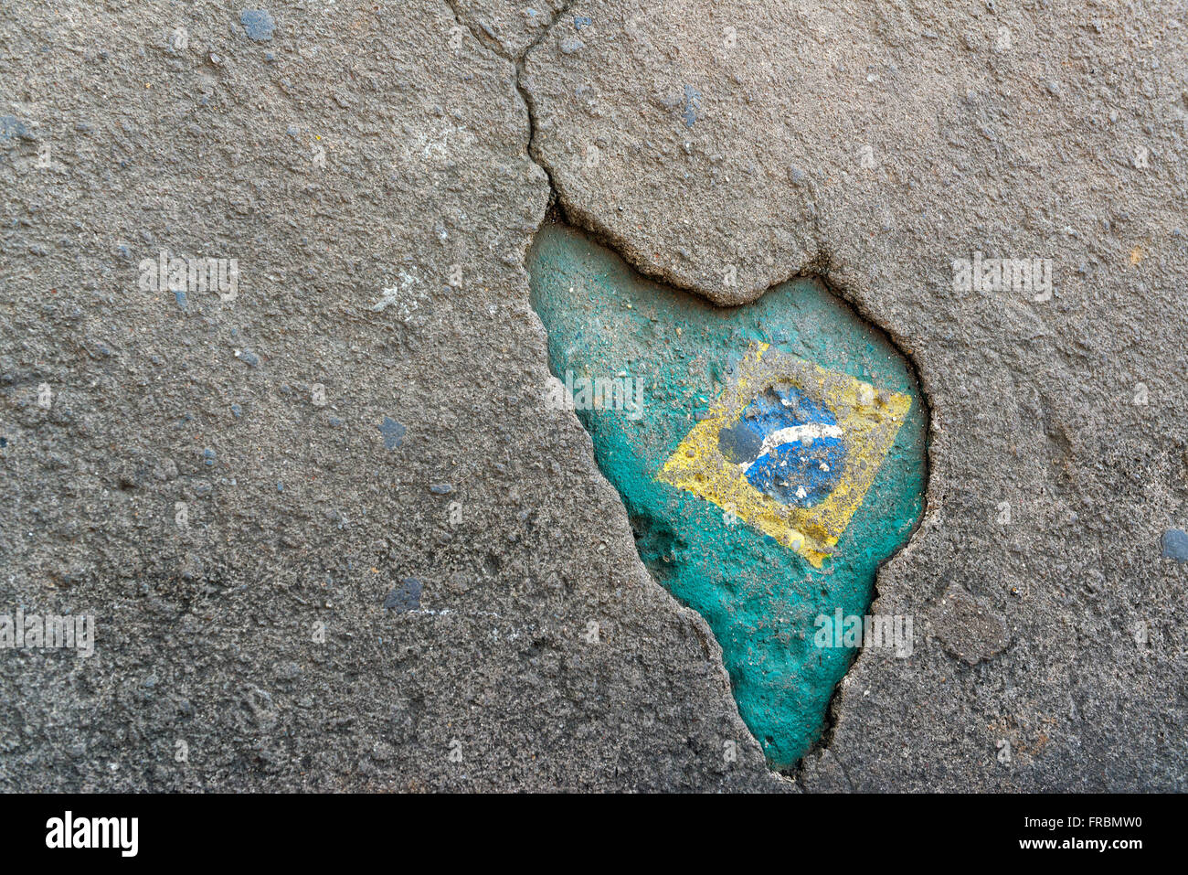 Hole in the sidewalk with design that resembles the map of Brazil Stock Photo