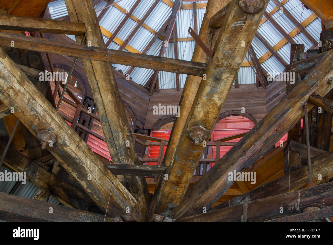 Aged and worn wooden rafters with rusting metal girders inside decaying building. Stock Photo