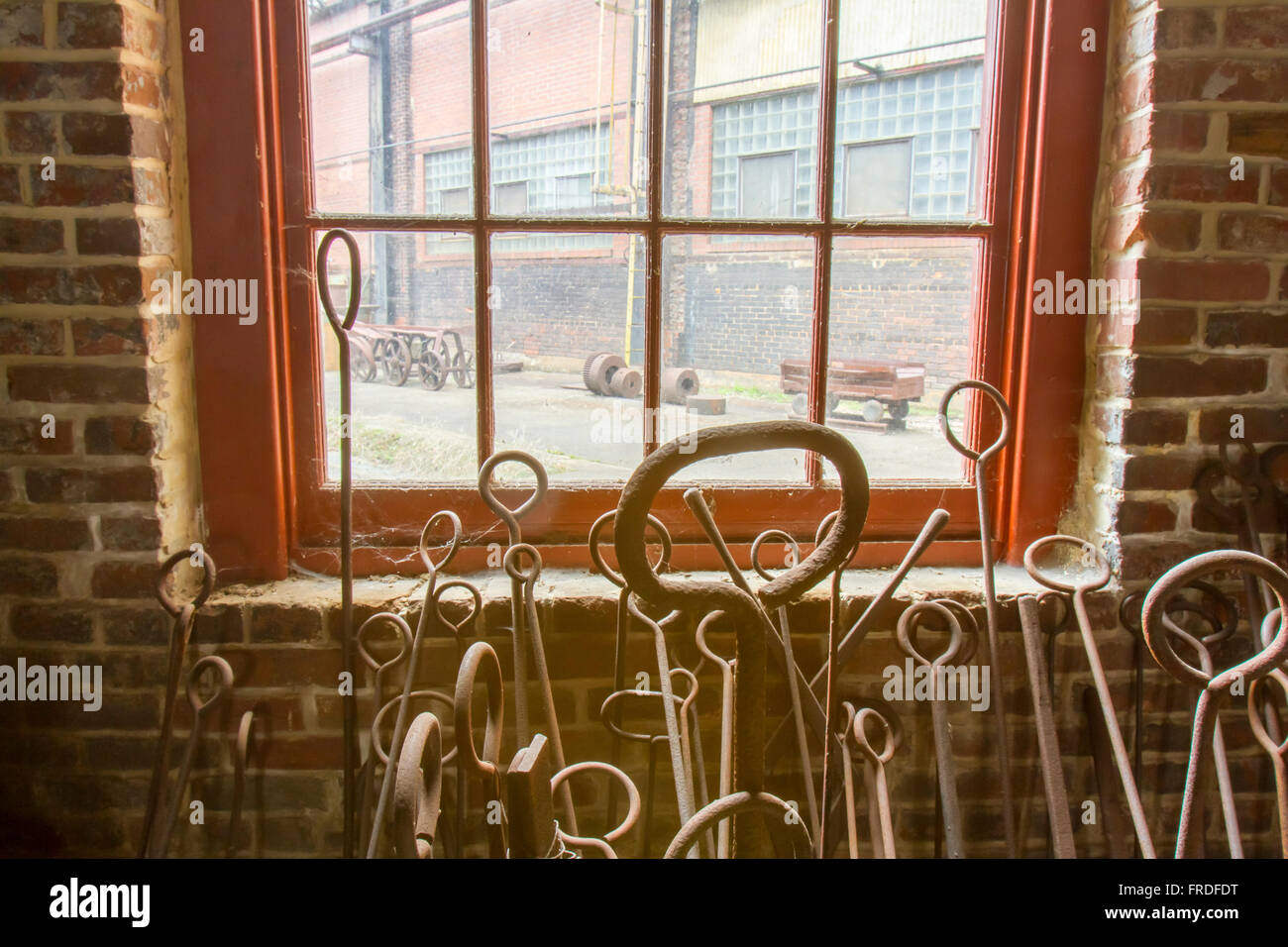 Rusting tools leaning against window with spider webs in brick blacksmith shop Stock Photo Alamy