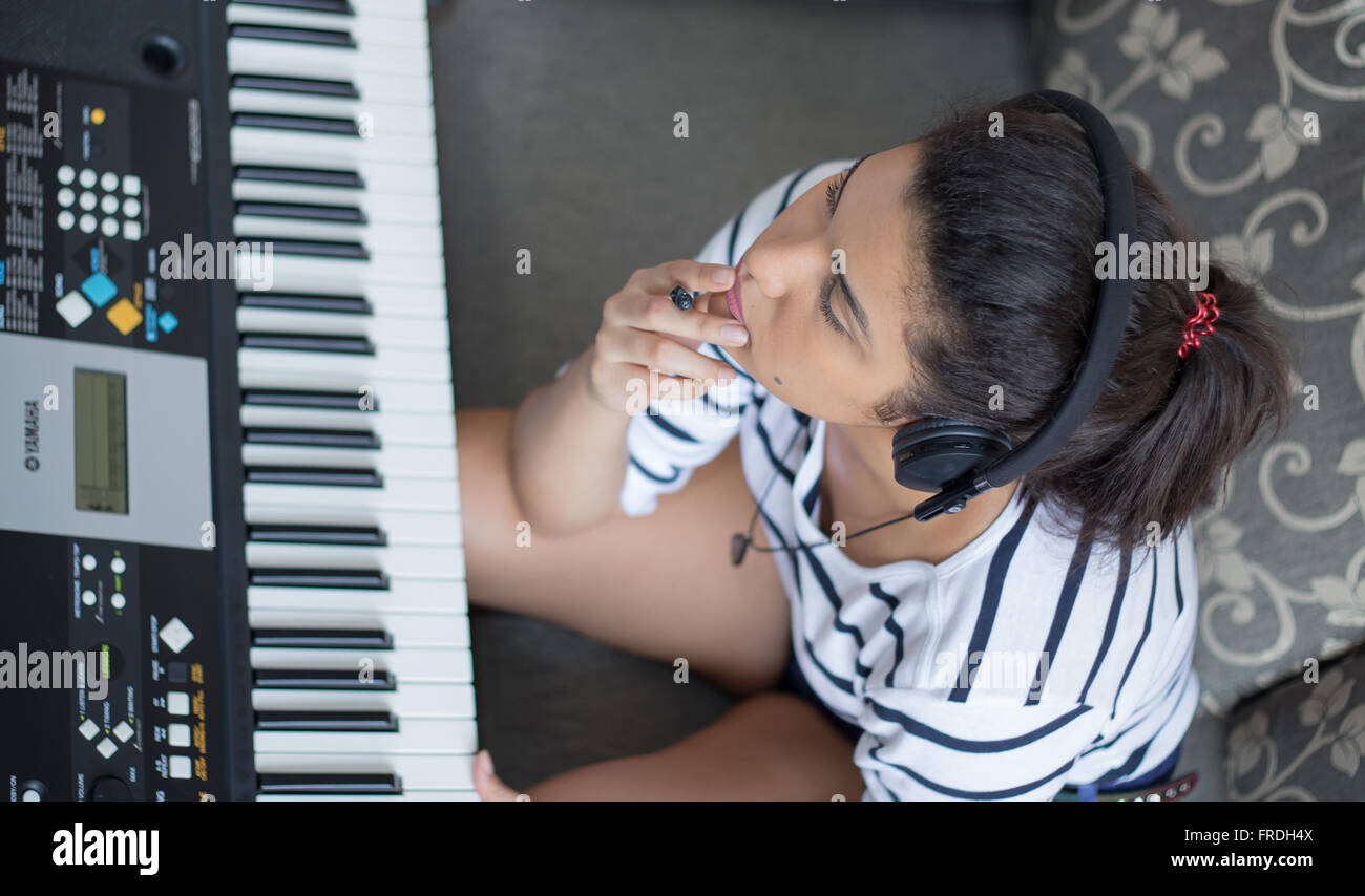 Girl composing a song at the keyboard. Stock Photo