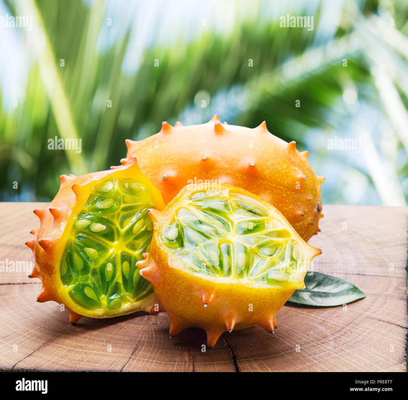 Kiwano fruits on the wooden table with green nature on the background. Stock Photo