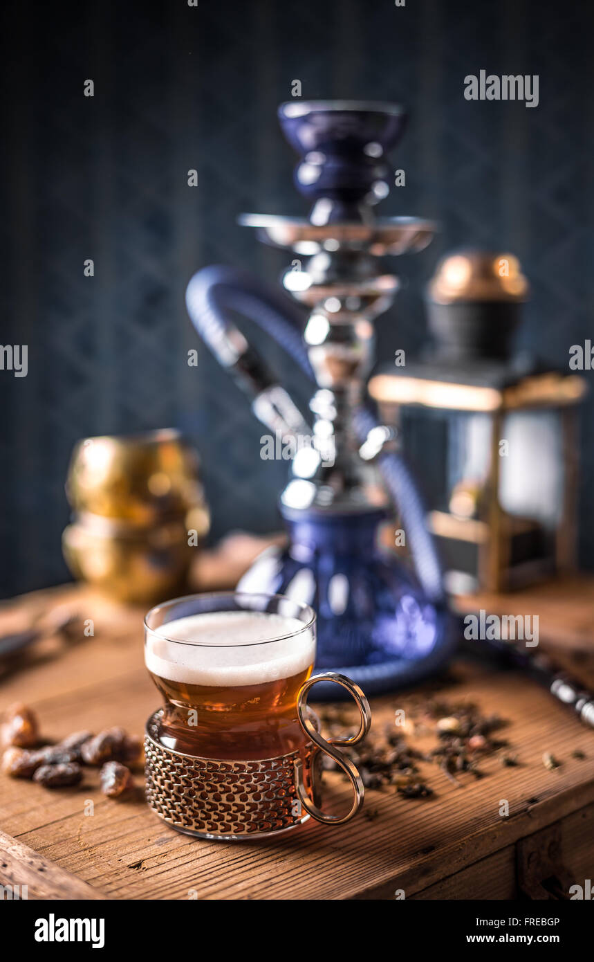 Cup of tea and hookah on old wooden table Stock Photo