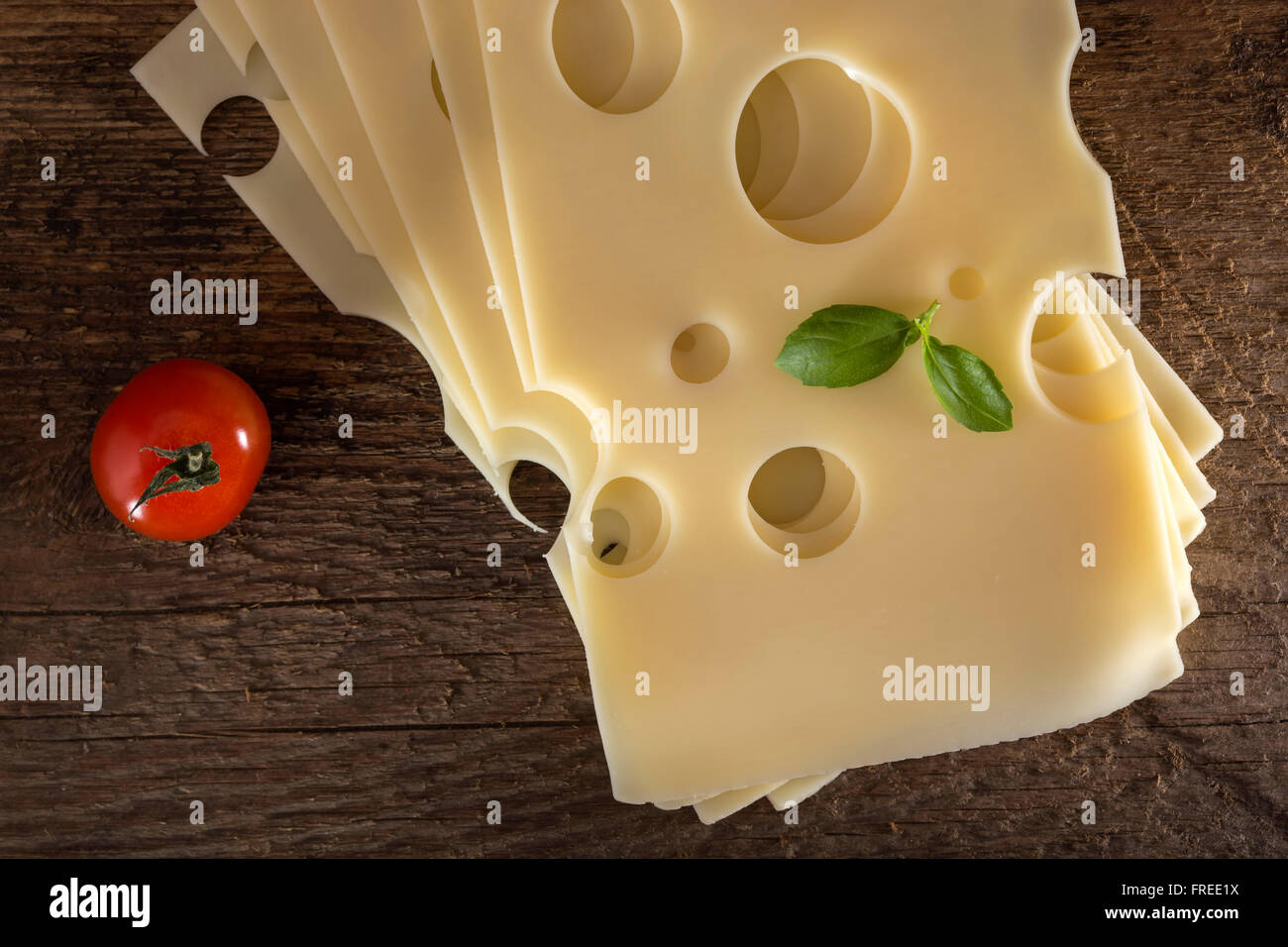 Slices of Emmental cheese on a wooden background Stock Photo