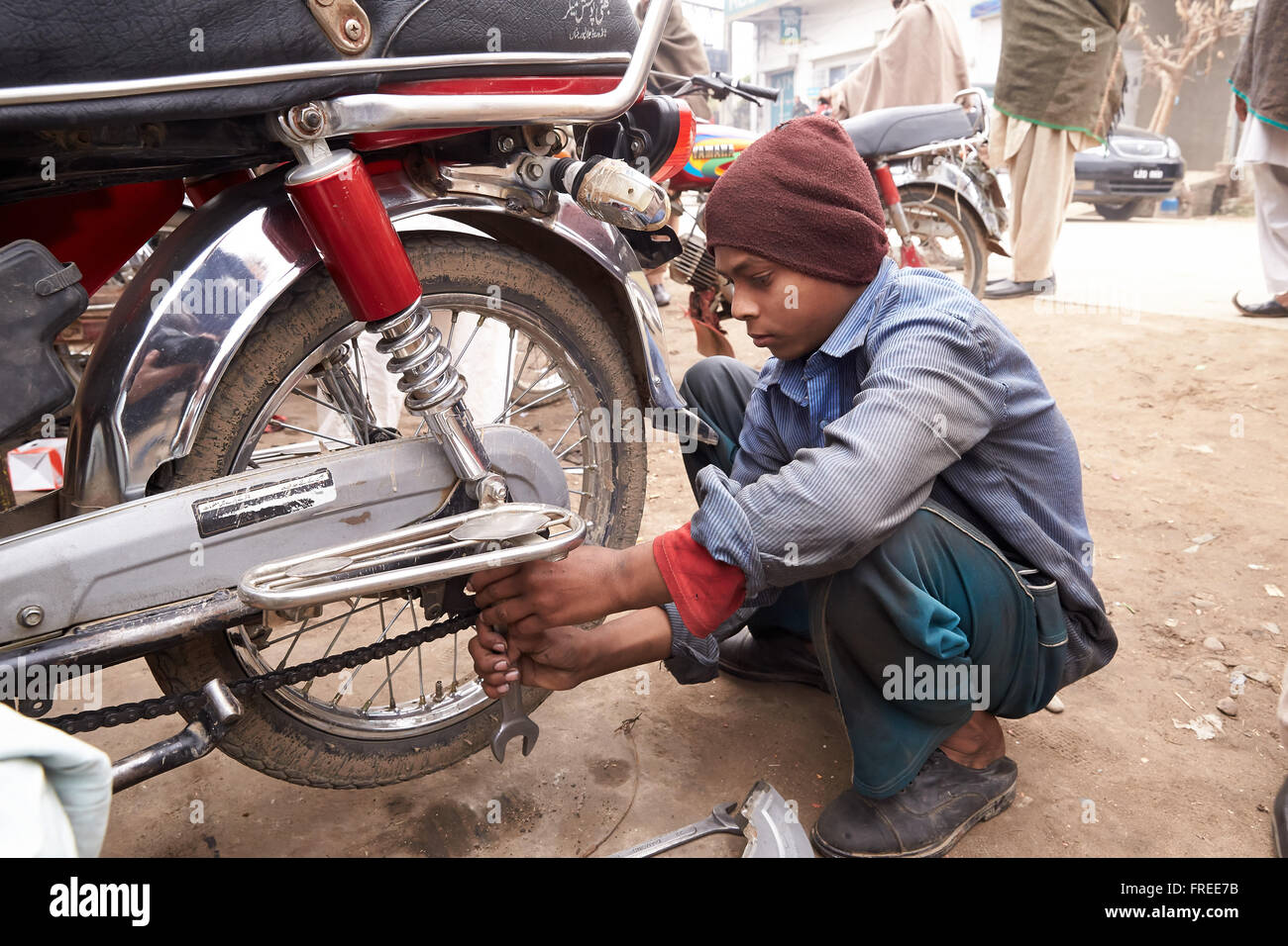 Young guy is repairing a motorcycle, motorcycle workshop, Kujerad, Pakistan Stock Photo