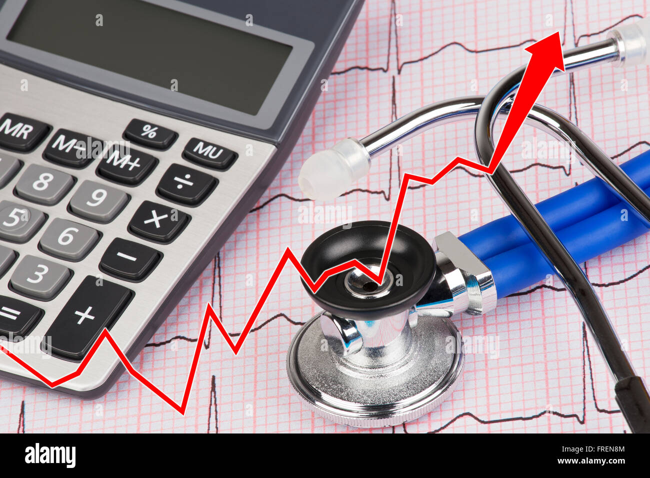 Close up of graph with an Electrocardiograph also known as a EKG or ECG graph with a stethoscope and calculator showing the high cost of medical care Stock Photo