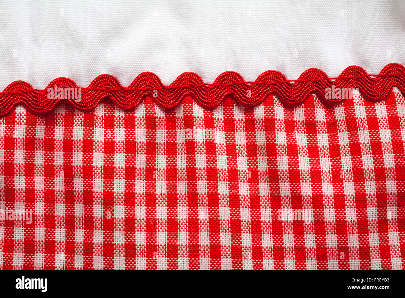 Detail of red checked gingham fabric material and trim on Baby C baby girl's dress Stock Photo