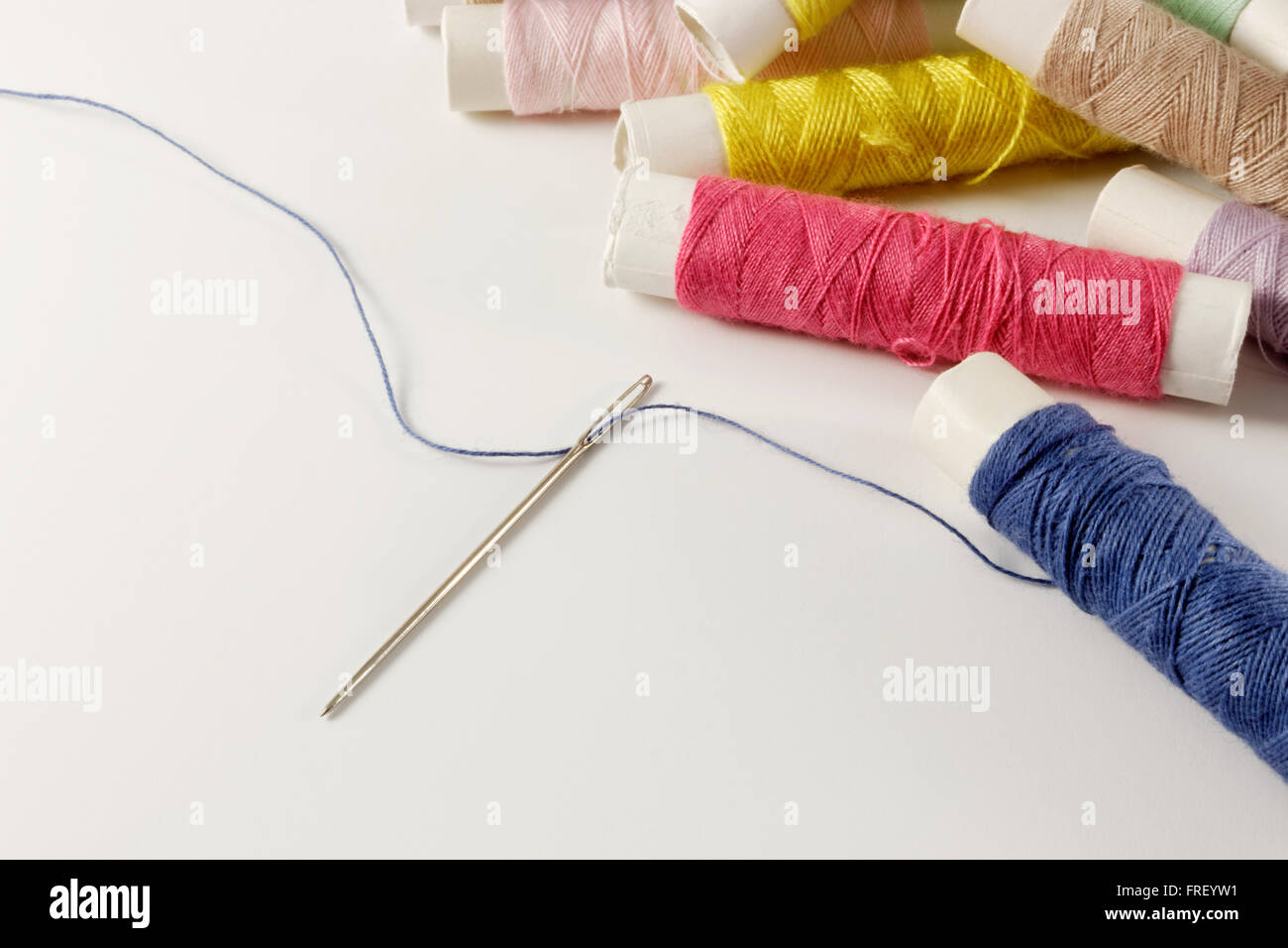 Sewing needle with yarn and threader Stock Photo - Alamy