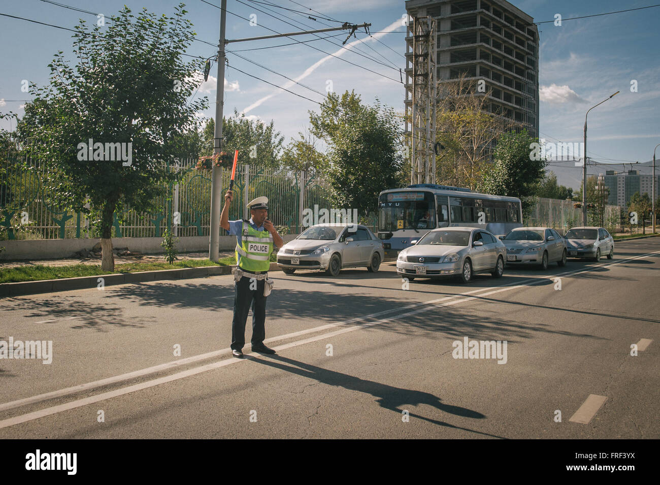 A Mongolian police officer controls traffic in Ulaan Baatar. Stock Photo