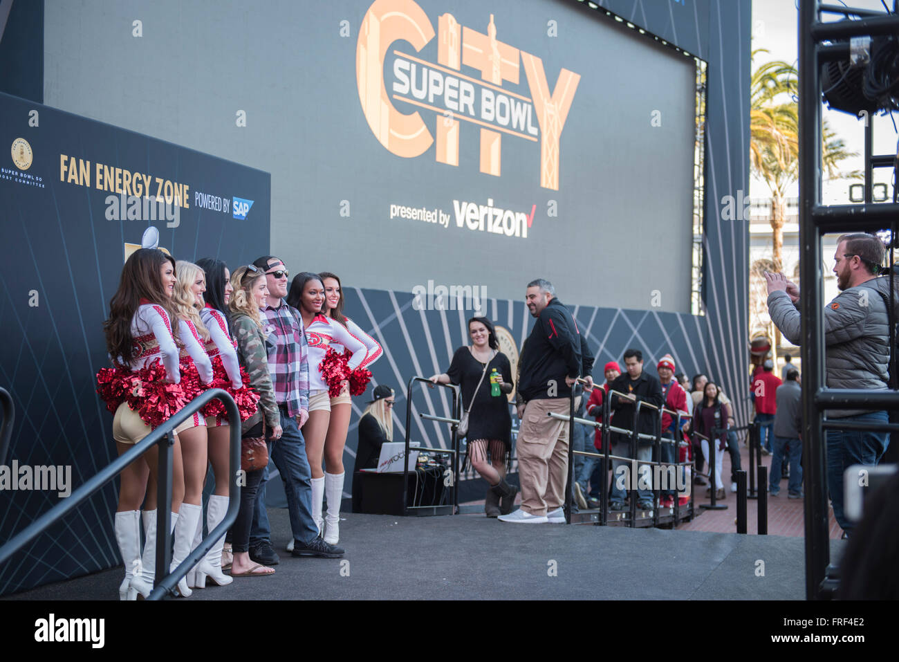 People having photographs taken with Cheerleaders at Super Bowl City in San Francisco before the 2016 Superbowl. California, USA Stock Photo