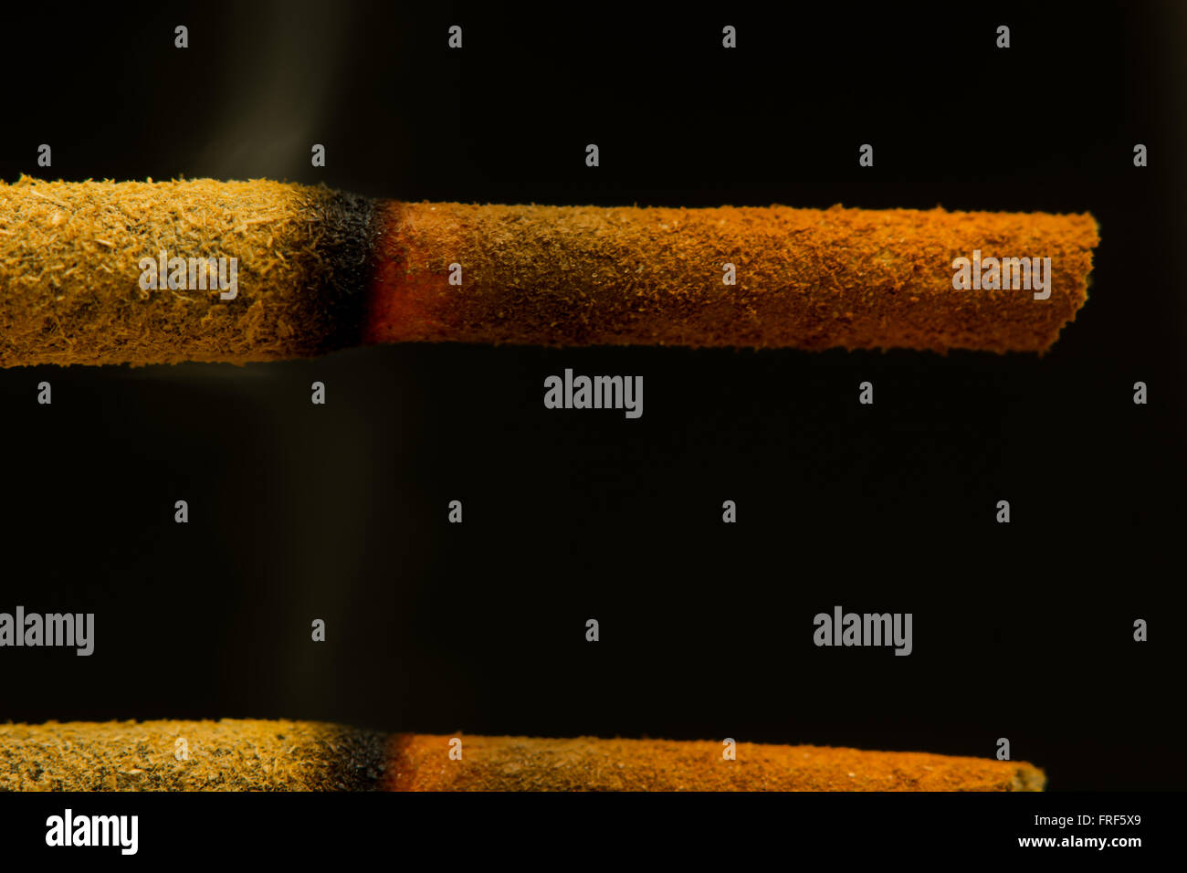 Incense sticks burning closeup. Two sticks alight showing pattern of