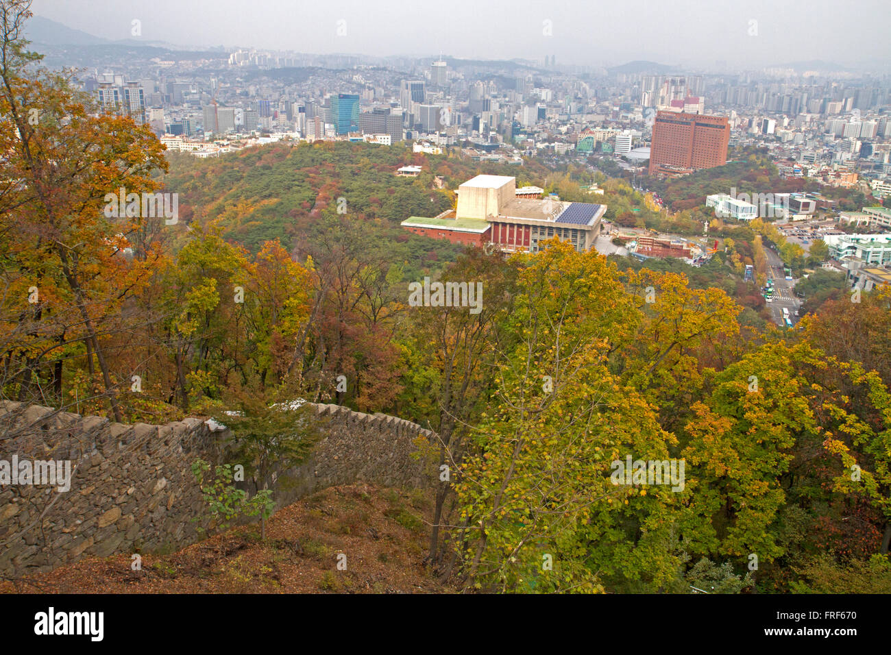 Seoul City Wall and autumn forest on the slopes of Namsan Stock Photo