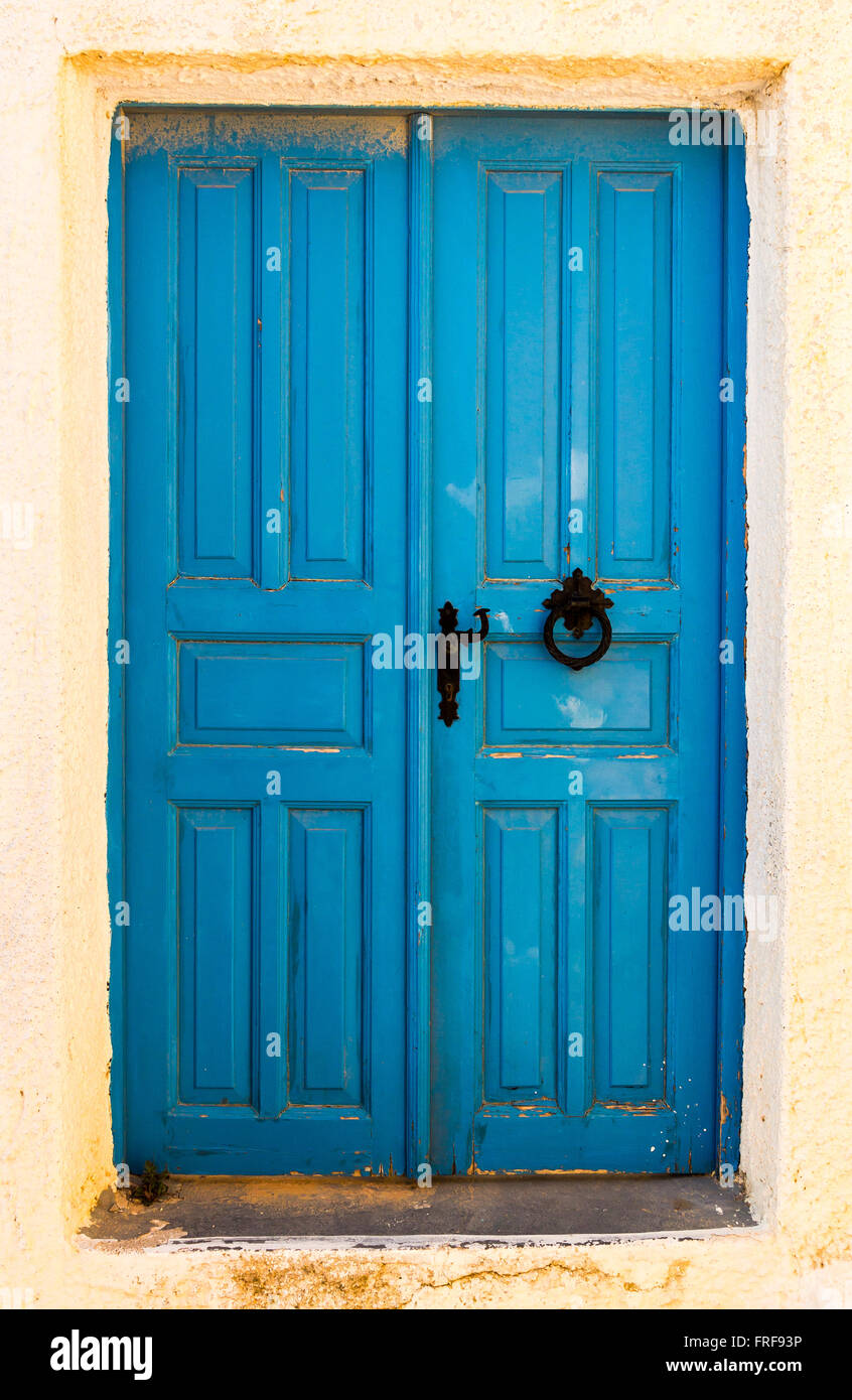 Vintage old blue door with black rusty doorknob in Santorini,Greece Stock Photo