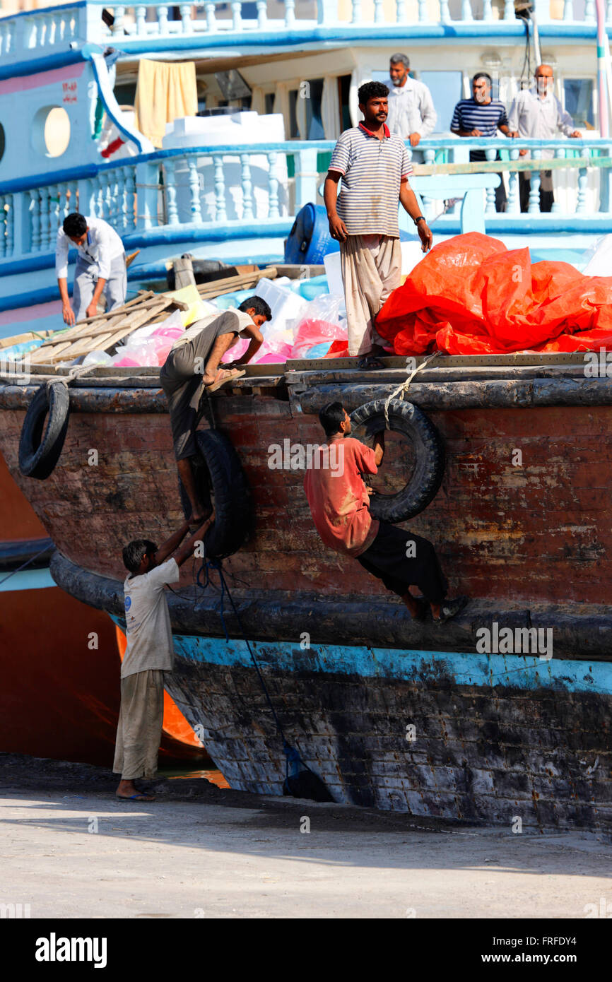 Dubai - Sharjah. Workers climbing onto a cargo ship in the port of Sharjah, United Arab Emirates Stock Photo