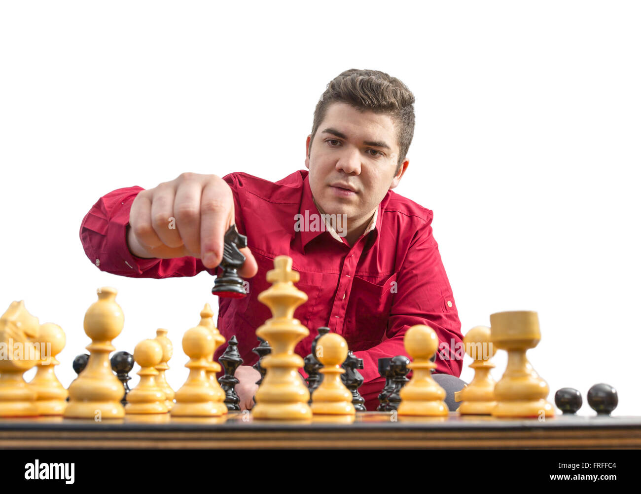 A young man playing chess isolated against a white background. Stock Photo
