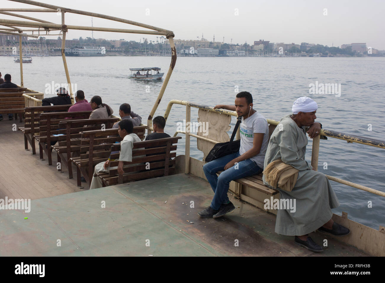 Commuters sit on the top deck of the state-run ferry across the River Nile at Luxor, Nile Valley, Egypt. Stock Photo