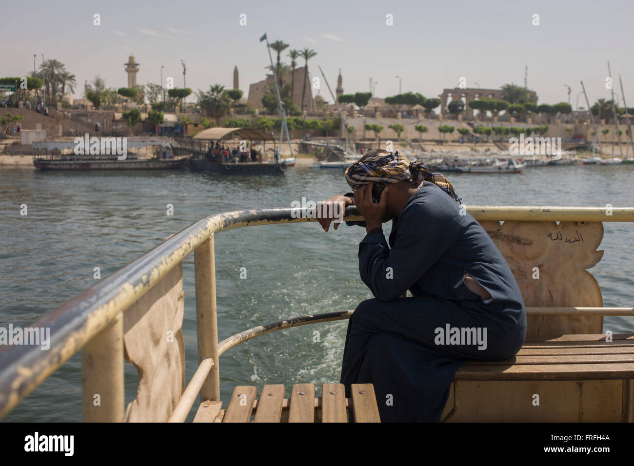 A local man talks on his mobile phone on the top deck of the state-run ferry across the River Nile at Luxor, Nile Valley, Egypt. Stock Photo