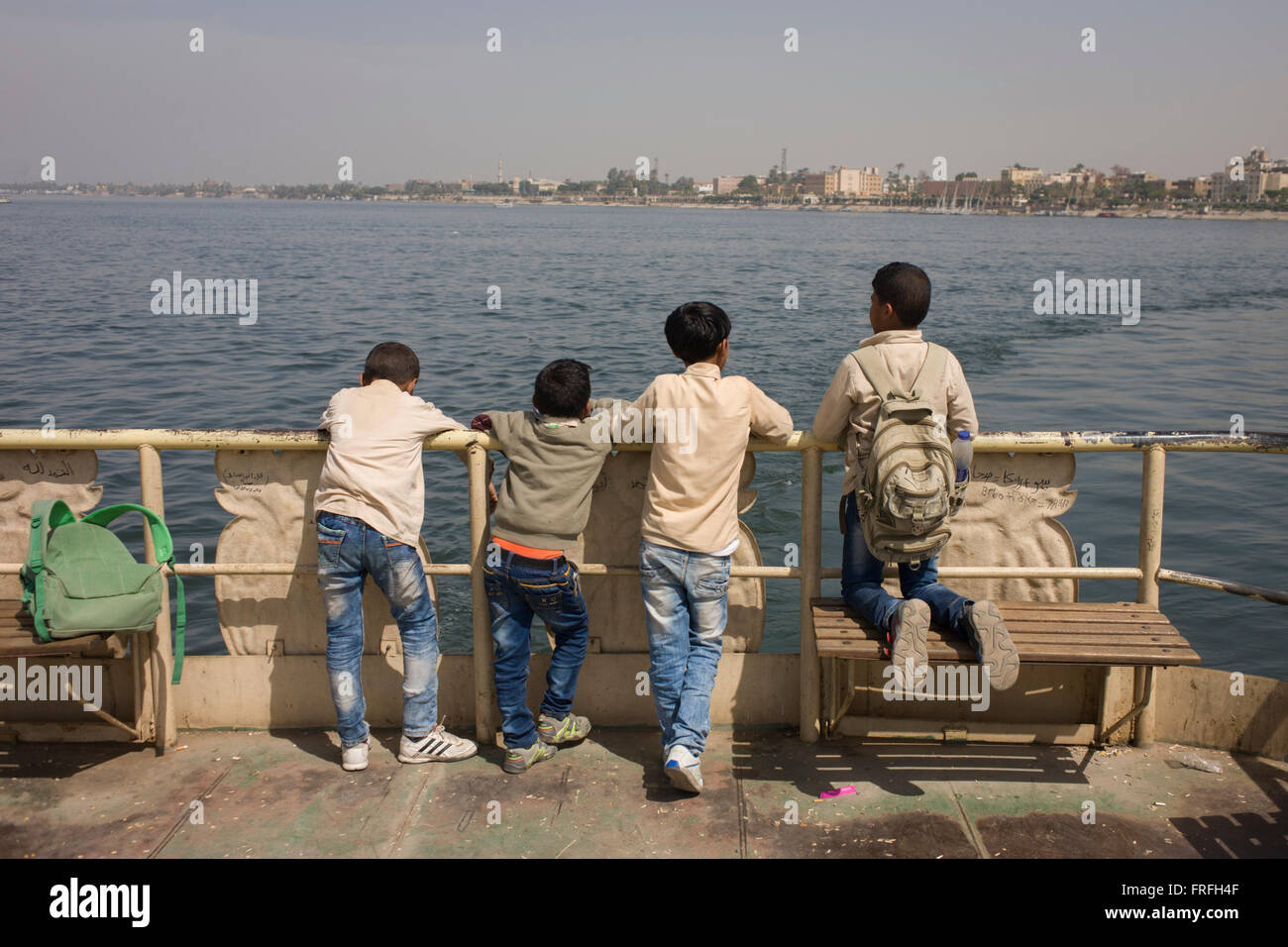 Schoolboys stand on the top deck of the state-run ferry across the River Nile at Luxor, Nile Valley, Egypt. Stock Photo