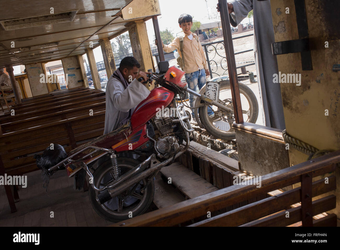 A motorbike is heaved off the state-run ferry across the River Nile at Luxor, Nile Valley, Egypt. Stock Photo