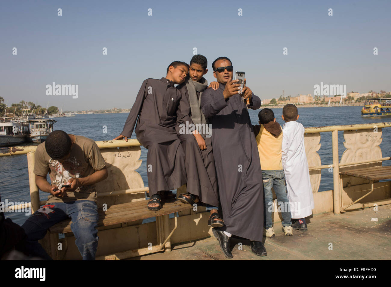 A father takes a selfie with his two boys on the top deck of the state-run ferry across the River Nile at Luxor, Nile Valley, Egypt. Stock Photo