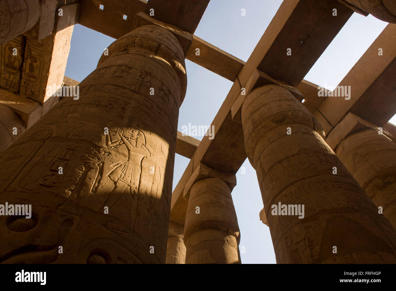 The tall columns in the Hypostyle hall at the Temple of Amun at Karnak, Luxor, Nile Valley, Egypt. The Karnak Temple Complex is the largest religious building ever made, covering about 200 acres. It comprises a vast mix of decayed temples, chapels, pylons, and other buildings built over 2,000 years and dedicated to the Theban triad of Amun, Mut, and Khonsu. The Hypostyle hall, at 54,000 square feet (16,459 meters) and featuring 134 columns, is still the largest room of any religious building in the world. Stock Photo