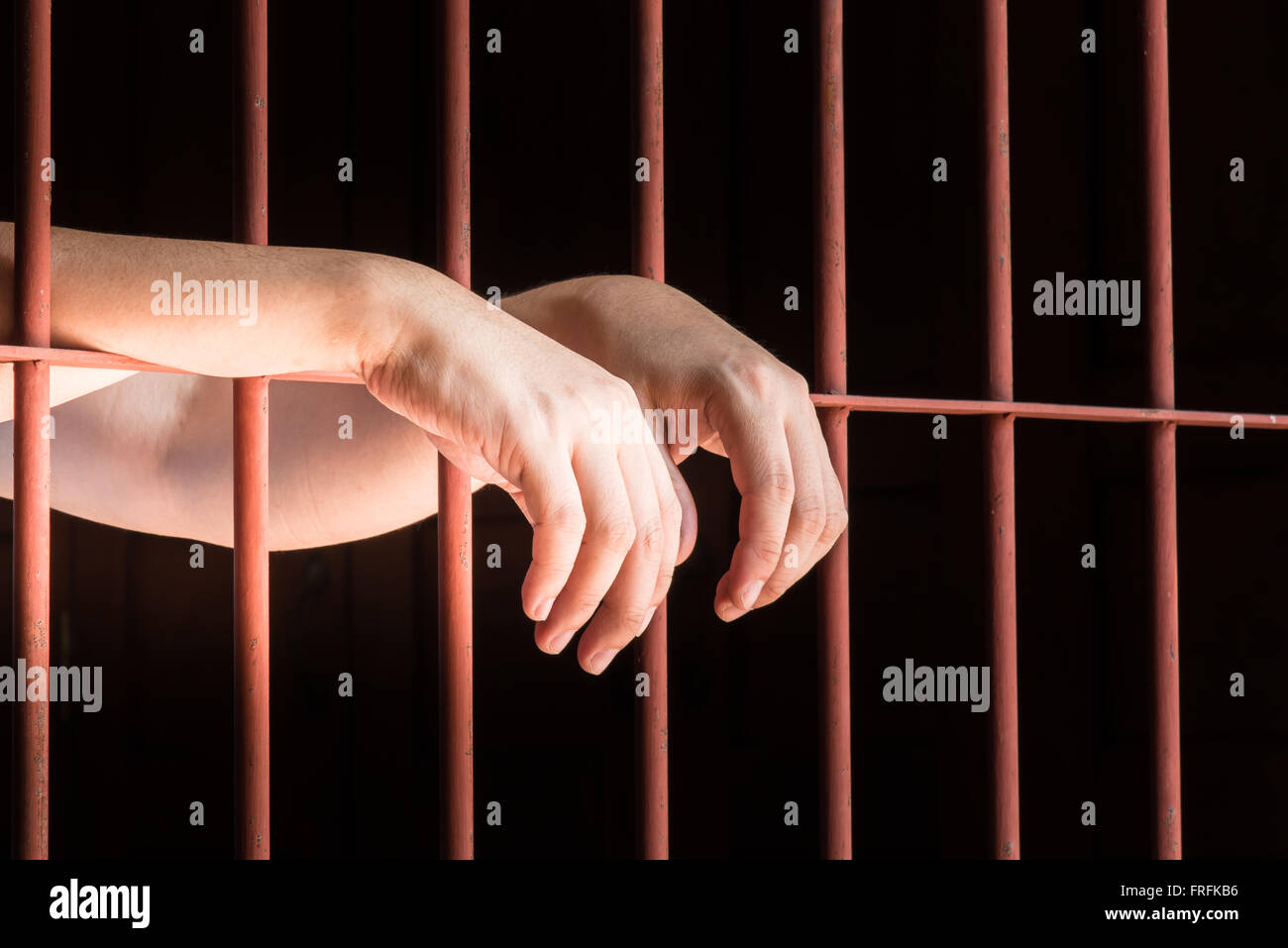 Close up hand of male muslim hanging on bar in jail. Stock Photo