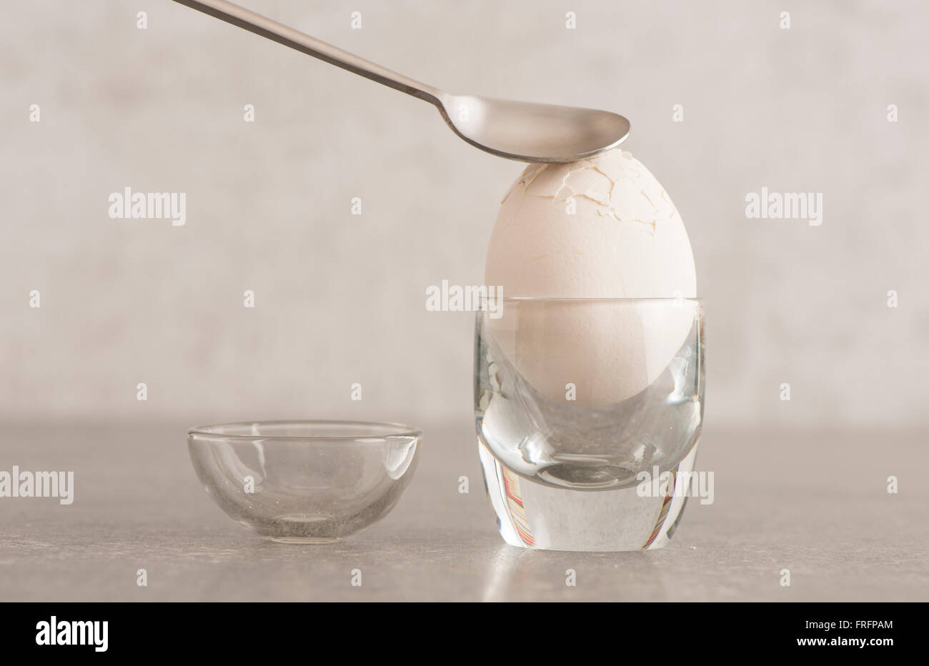 Boiled breakfast egg. The shell is cracked with a spoon. Concept of healthy eating and morning habits. Stock Photo