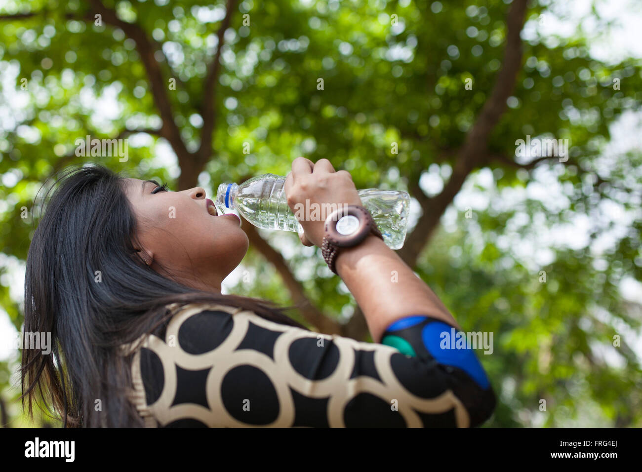 Dhaka, Bangladesh. 22nd March, 2016. A young girl drinking water from bottle in a park in Dhaka, Bangladesh on March 22, 2016. Millions of inhabitants of Dhaka face severe water crisis during the blistering summer months.Safe drinking water crisis has become one of the major and common problems now-a-days in Bangladesh, especially in Dhaka city. Credit:  zakir hossain chowdhury zakir/Alamy Live News Stock Photo