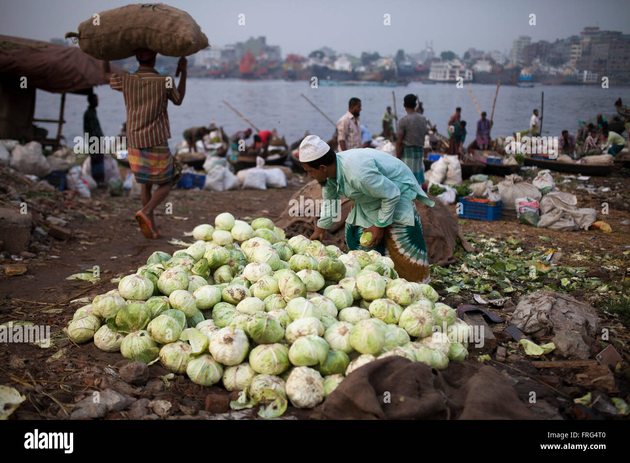 Dhaka, Bangladesh. 21st March, 2016. People collect vegetable from the wholesale market at the bank of river Buriganga in Dhaka, Bangladesh on March 21, 2016. A large swathe of the Buriganga River which is the lifeline of the capital has turned pitch-black with toxic waste, oil and chemicals flowing into it from industrial units.  Buriganga river, which flows by Dhaka is now one of the most polluted and biologically dead rivers in Bangladesh. Credit:  zakir hossain chowdhury zakir/Alamy Live News Stock Photo