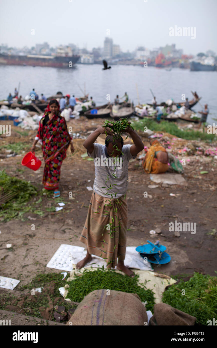 Dhaka, Bangladesh. 21st March, 2016. People collect vegetable from the wholesale market at the bank of river Buriganga in Dhaka, Bangladesh on March 21, 2016. A large swathe of the Buriganga River which is the lifeline of the capital has turned pitch-black with toxic waste, oil and chemicals flowing into it from industrial units.  Buriganga river, which flows by Dhaka is now one of the most polluted and biologically dead rivers in Bangladesh. Credit:  zakir hossain chowdhury zakir/Alamy Live News Stock Photo