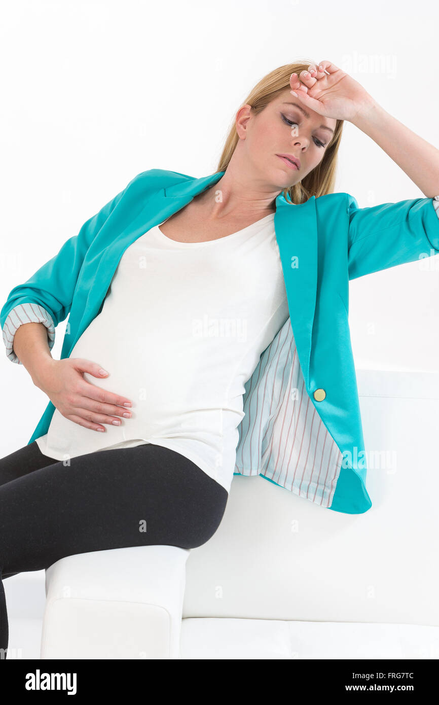 Pregnant woman getting a contraction at home in the living room Stock Photo
