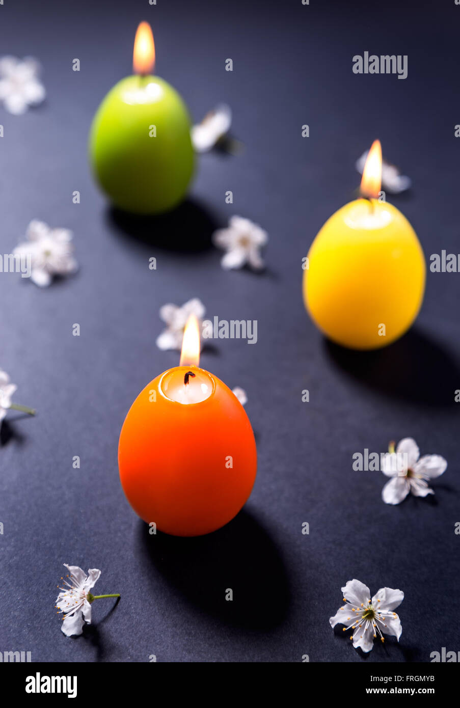 Colored wax candles in the shape of Easter egg with flowers Stock Photo