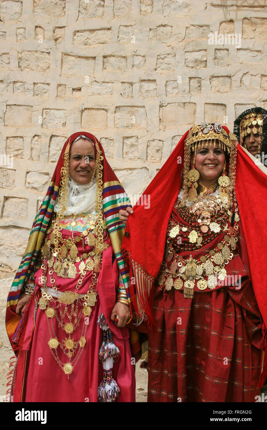 Tunisian women wearing traditional dresses golden jewelry and ornaments  going to a wedding along with the bride, Sahara borders Stock Photo - Alamy