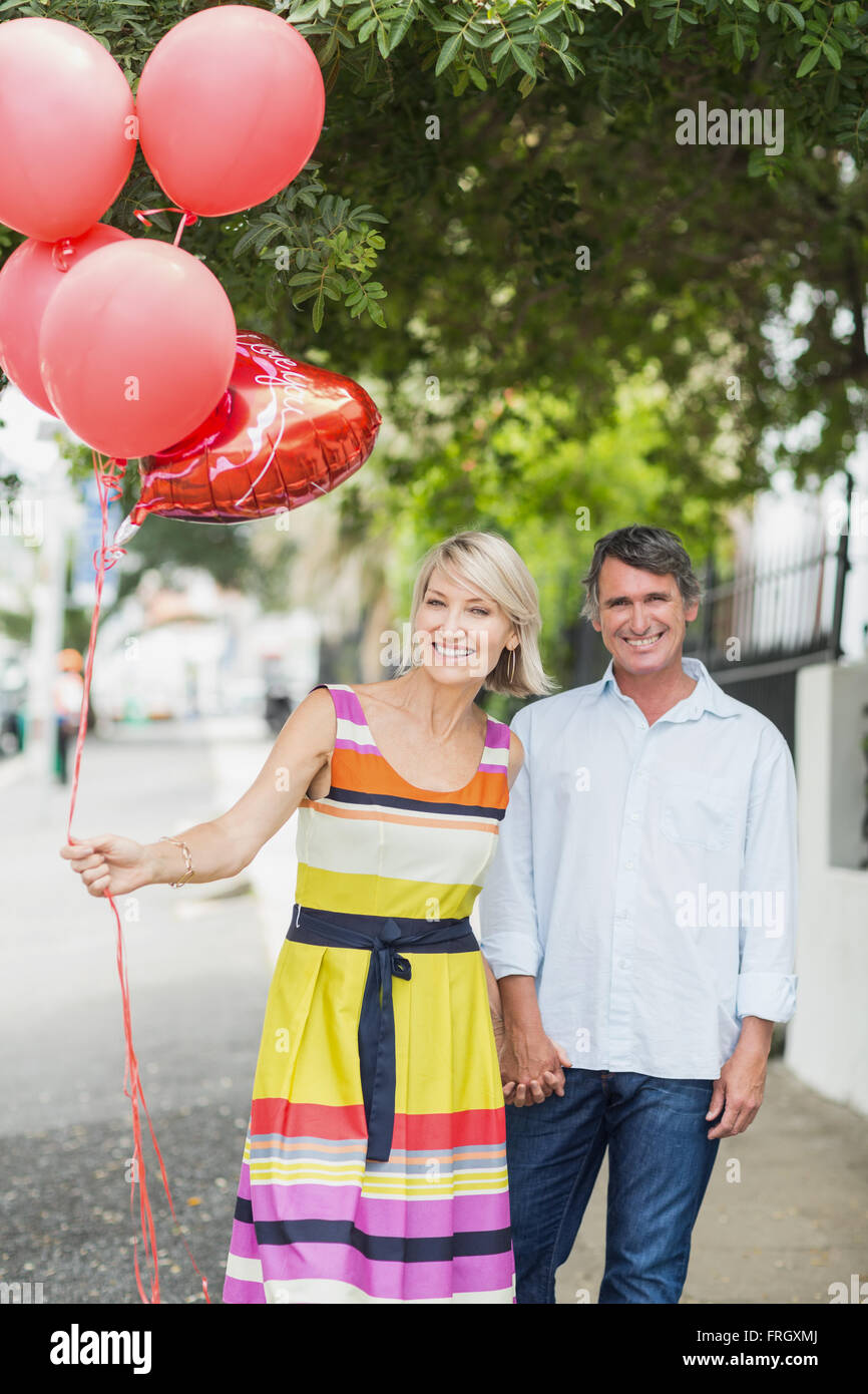 Portrait of happy couple with balloons Stock Photo - Alamy