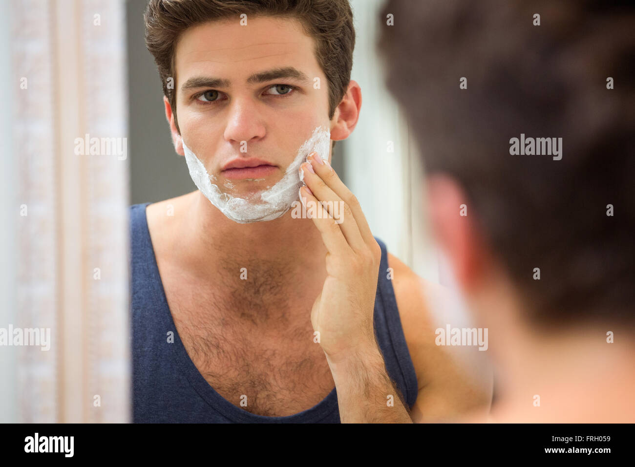 Young man applying shaving foam on his face Stock Photo Alamy