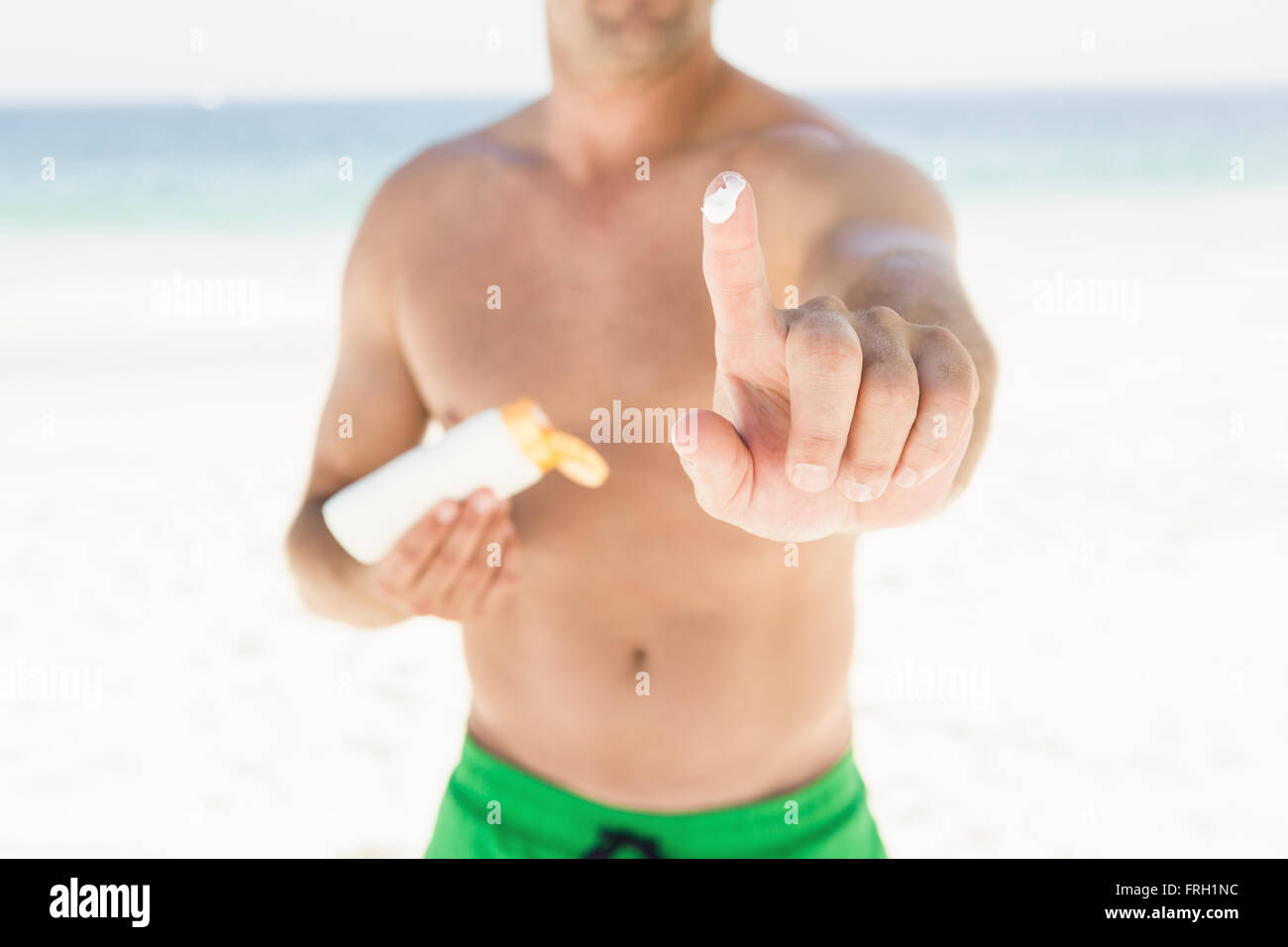 Portrait of man applying sun cream Stock Photo