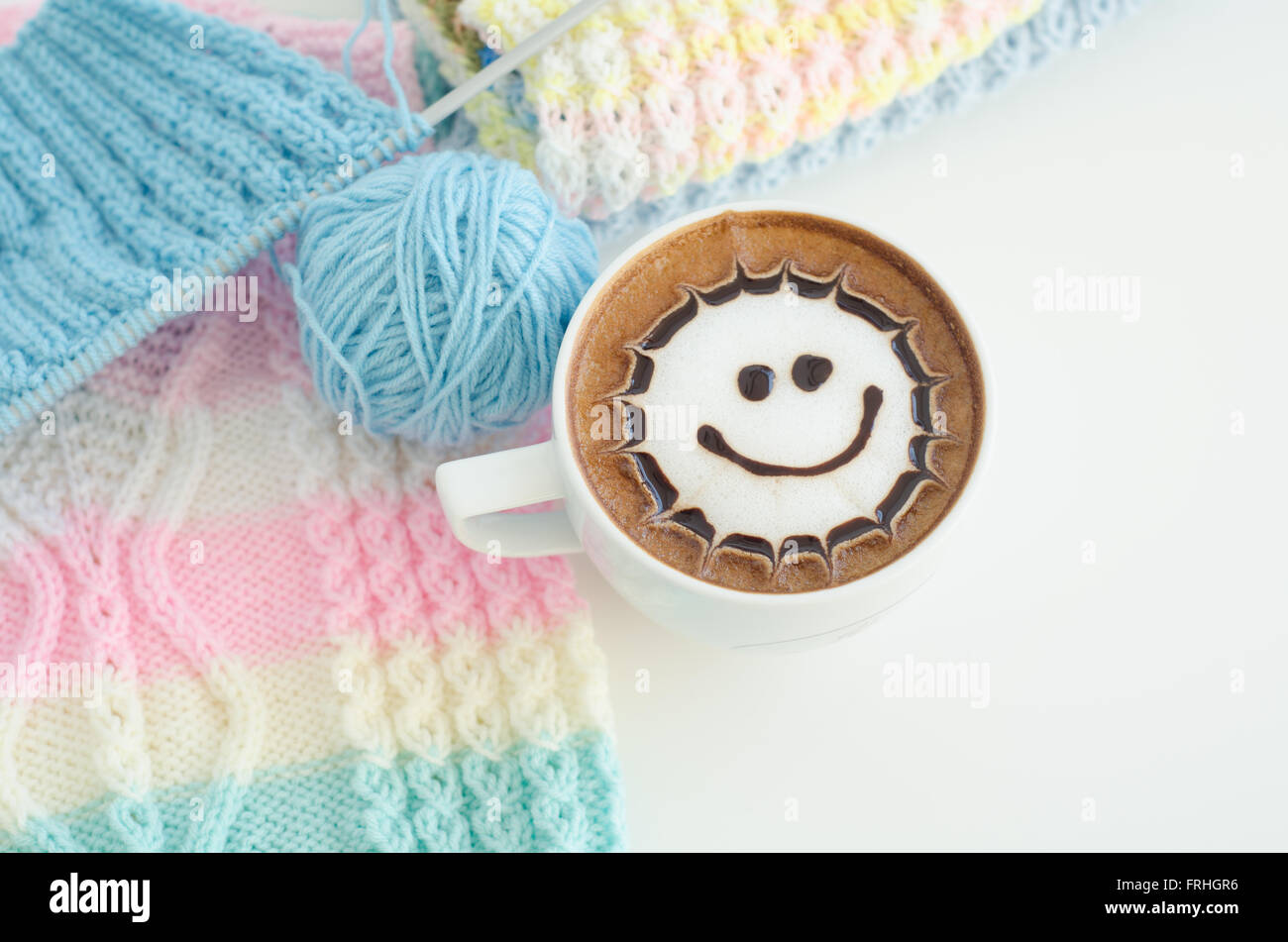 A cup of latte art and knitted vest Stock Photo