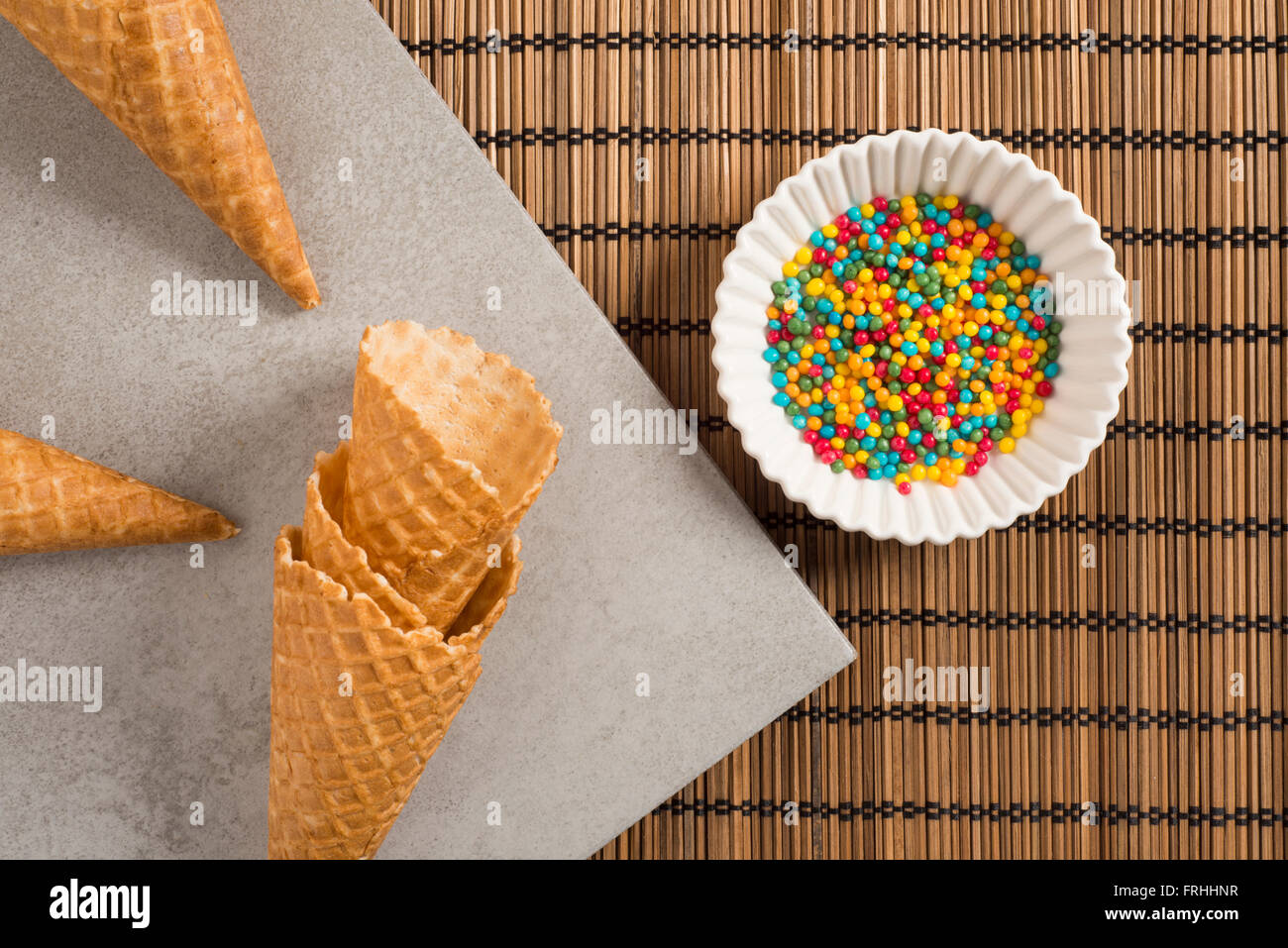 Colorful sugar sprinkles and ice cream cones. Preparation for party or celebration. Concept of food styling or colorful birthday Stock Photo
