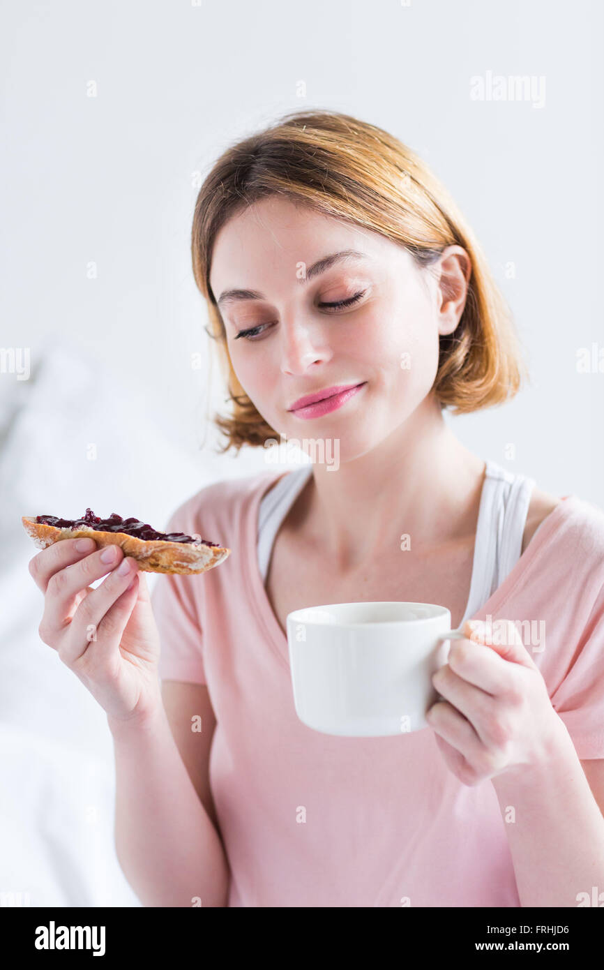 Woman eating a jam sandwich Stock Photo Alamy