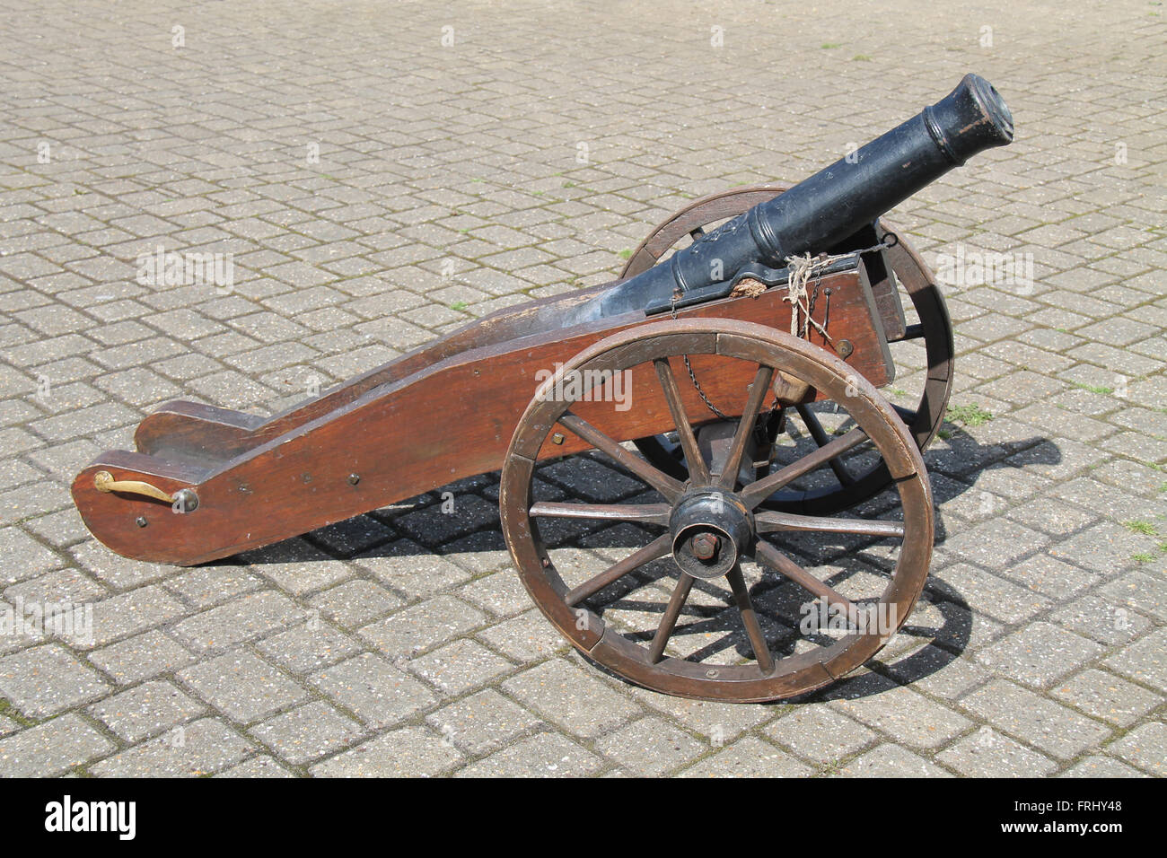 A Vintage Naval Cannon on Large Wooden Wheels. Stock Photo