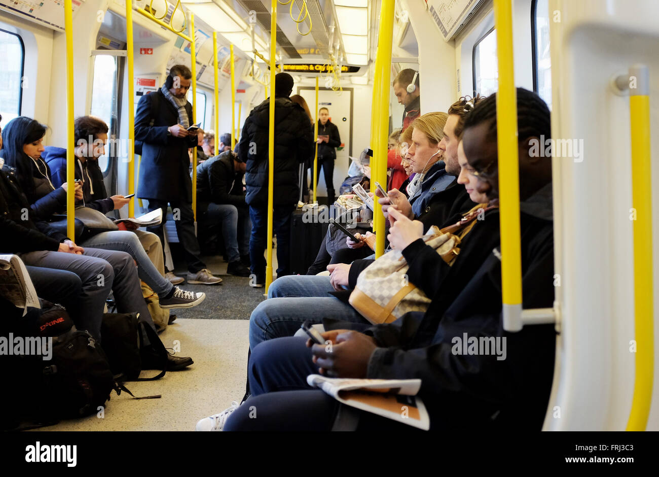 Commuters using their smart phones and electronic devices while