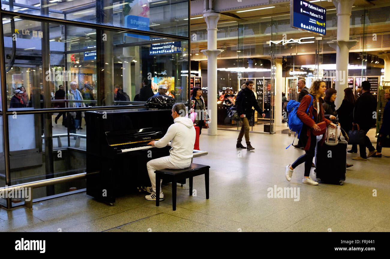 Man playing one of the pianos in St Pancras International Railway Station  in London UK Stock Photo - Alamy