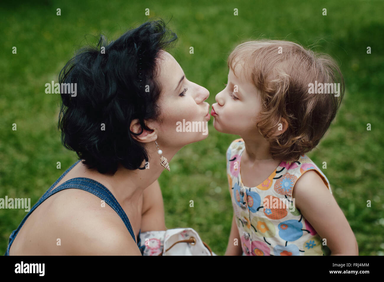 Mom kissing of little daughter Stock Photo