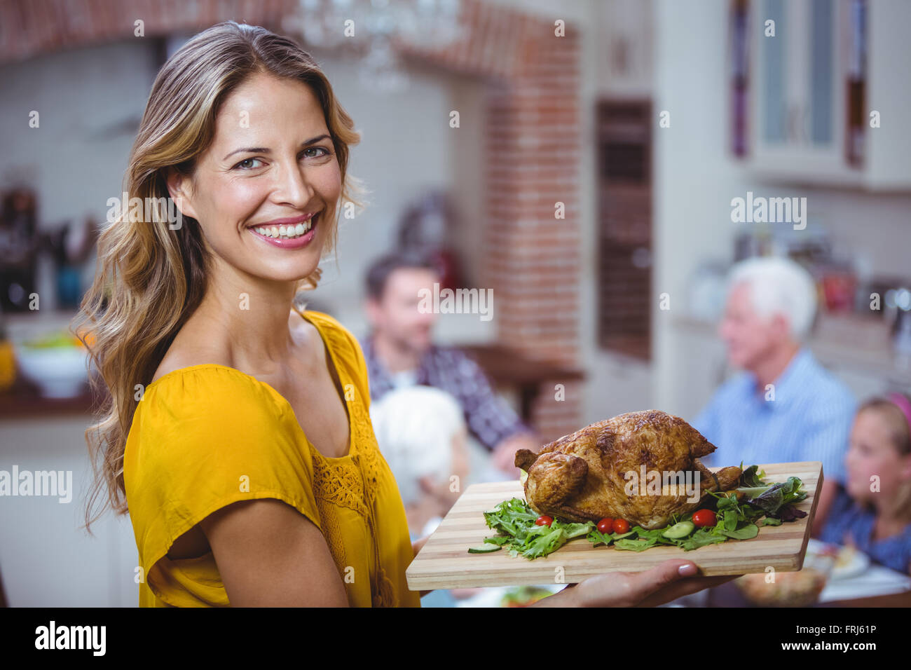 Portrait of smiling woman holding cutting board with meat Stock Photo