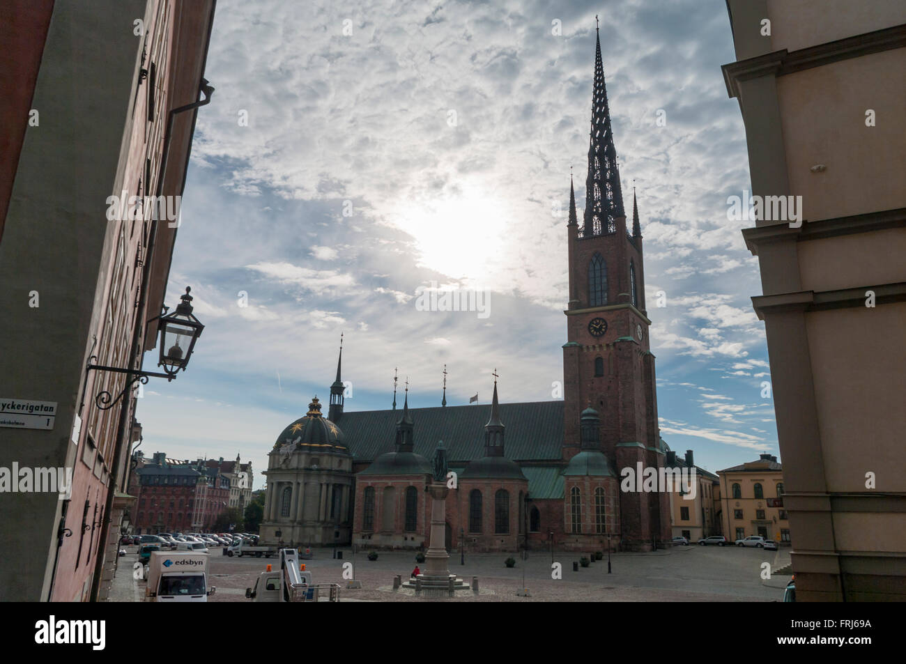 Gothic Riddarholmskyrkan church with its distinctive cast iron spire photographed against the sun. Stockholm, Sweden. Stock Photo