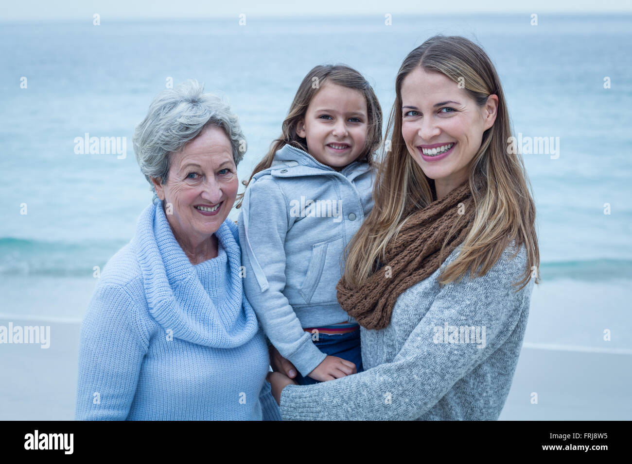 Happy three generations of women standing at beach Stock Photo