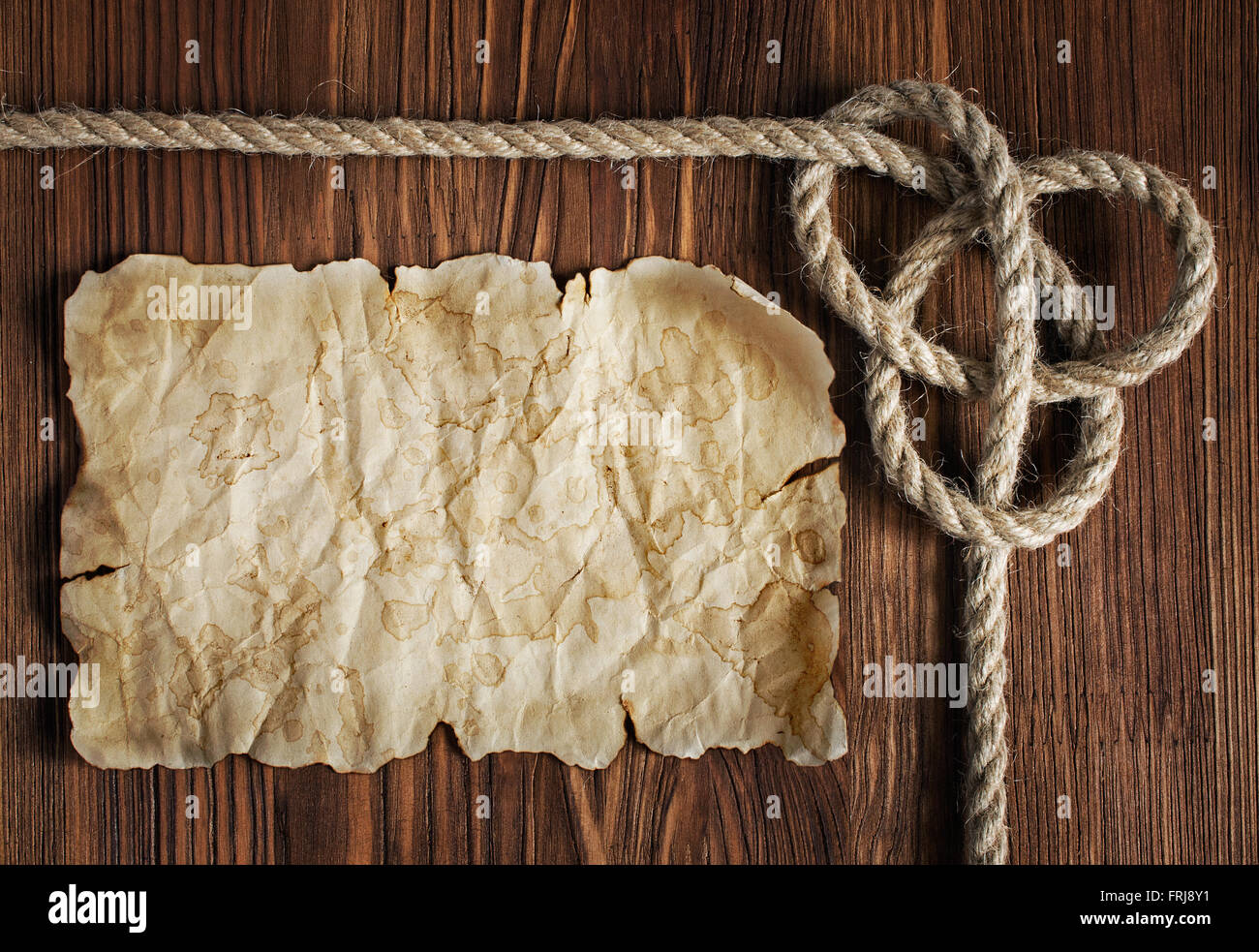 Nautical background with old paper or parchment or map and a rope with ...