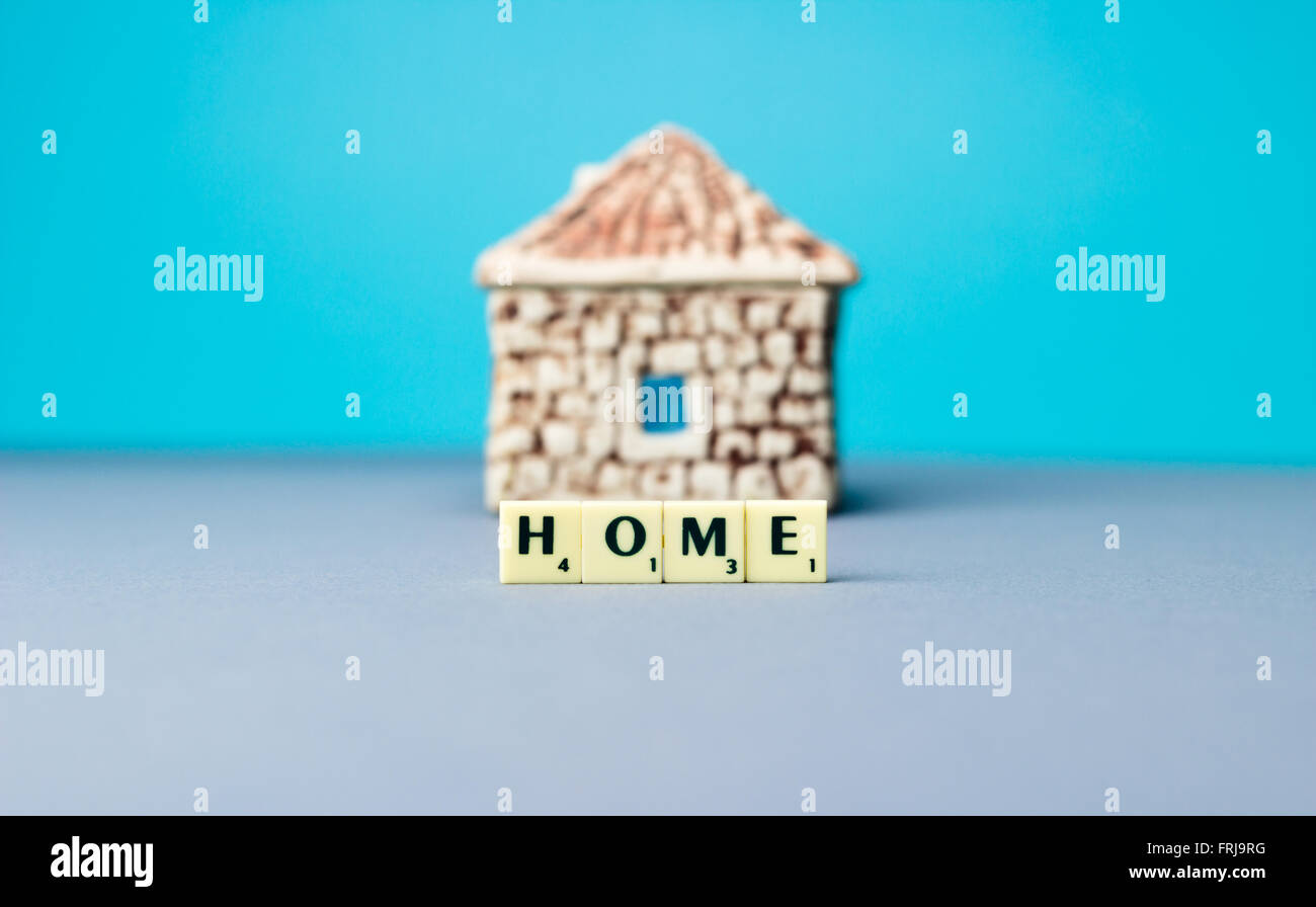 Ceramic house with sign on blue background Stock Photo