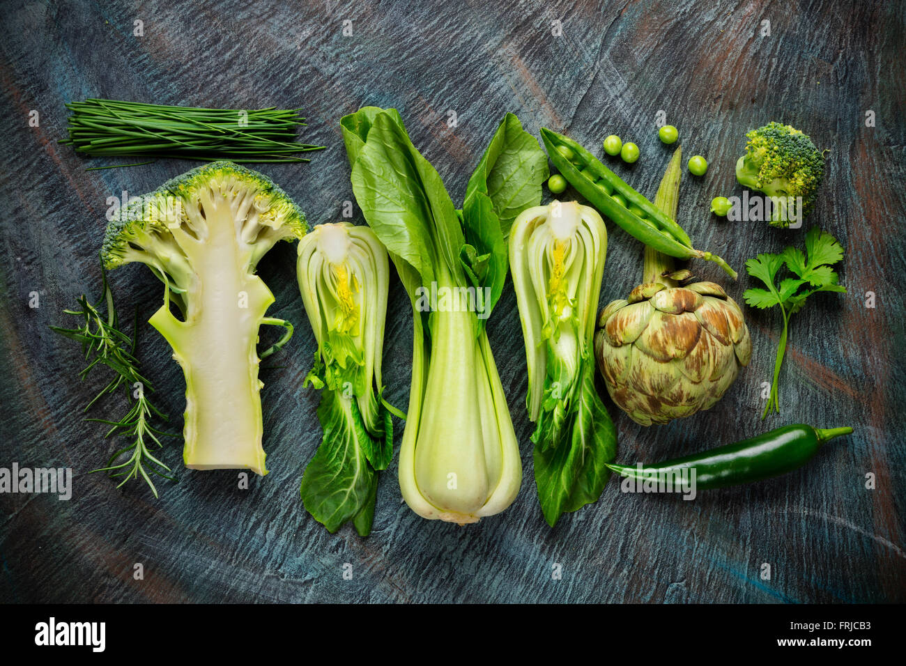 Collection of fresh green vegetables on black stone Stock Photo