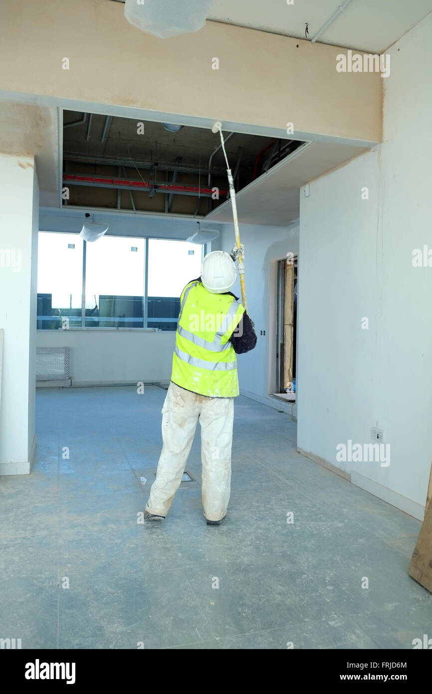 Commercial Decorator At Work Painting A High Ceiling With An